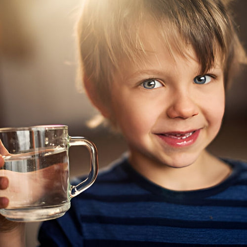 Boy Smiling holding glass of water