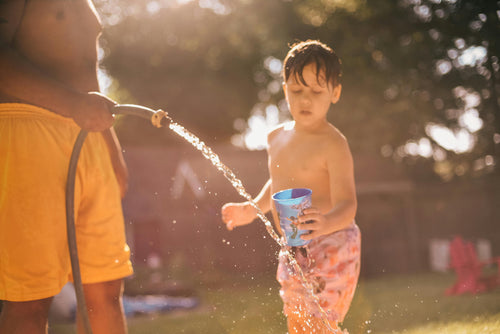 Boy Outside Filling Cup With Water