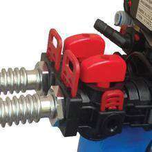 Two ribbed metal flex lines connected to a black plastic valve assembly with red handles and clips.