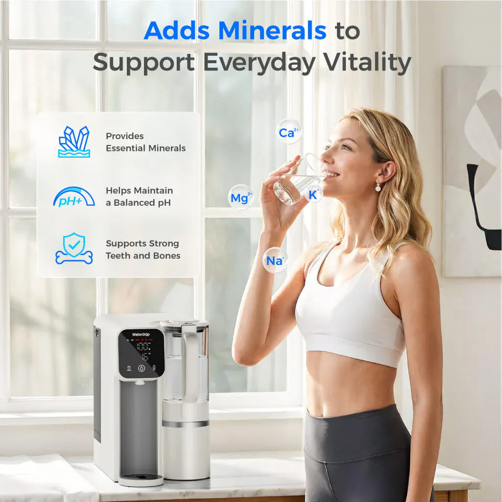 White Waterdrop M6SL countertop water filter on a marble counter next to a woman drinking from a glass.